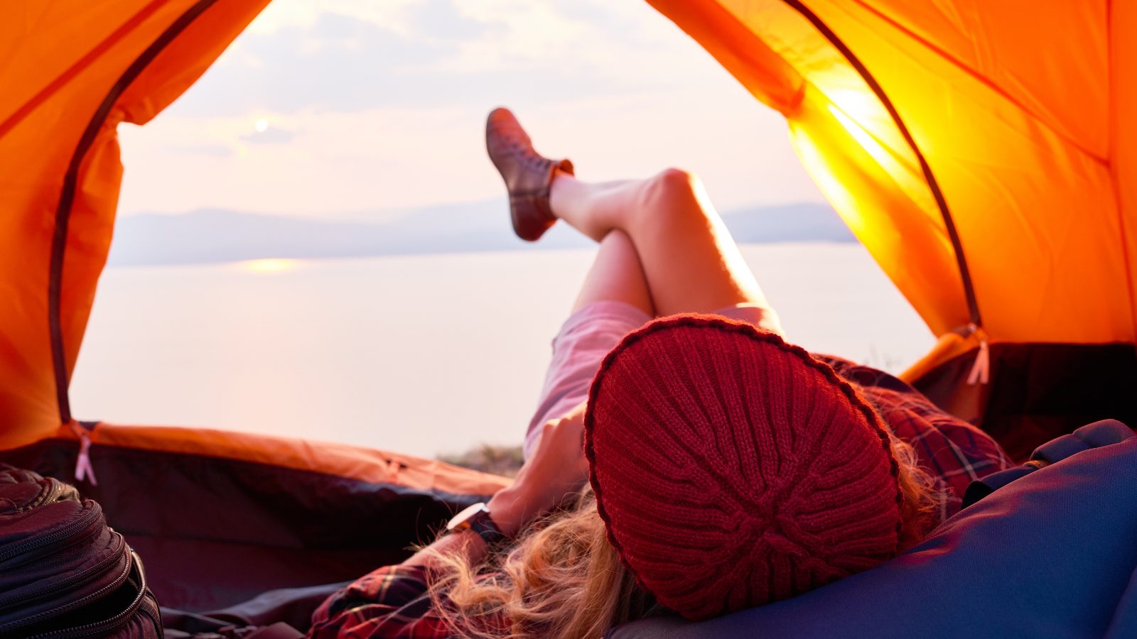 Woman lying in tent looking at view