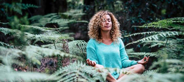 woman meditating in forest